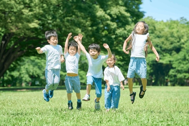 公園で跳びはねる子どもたち